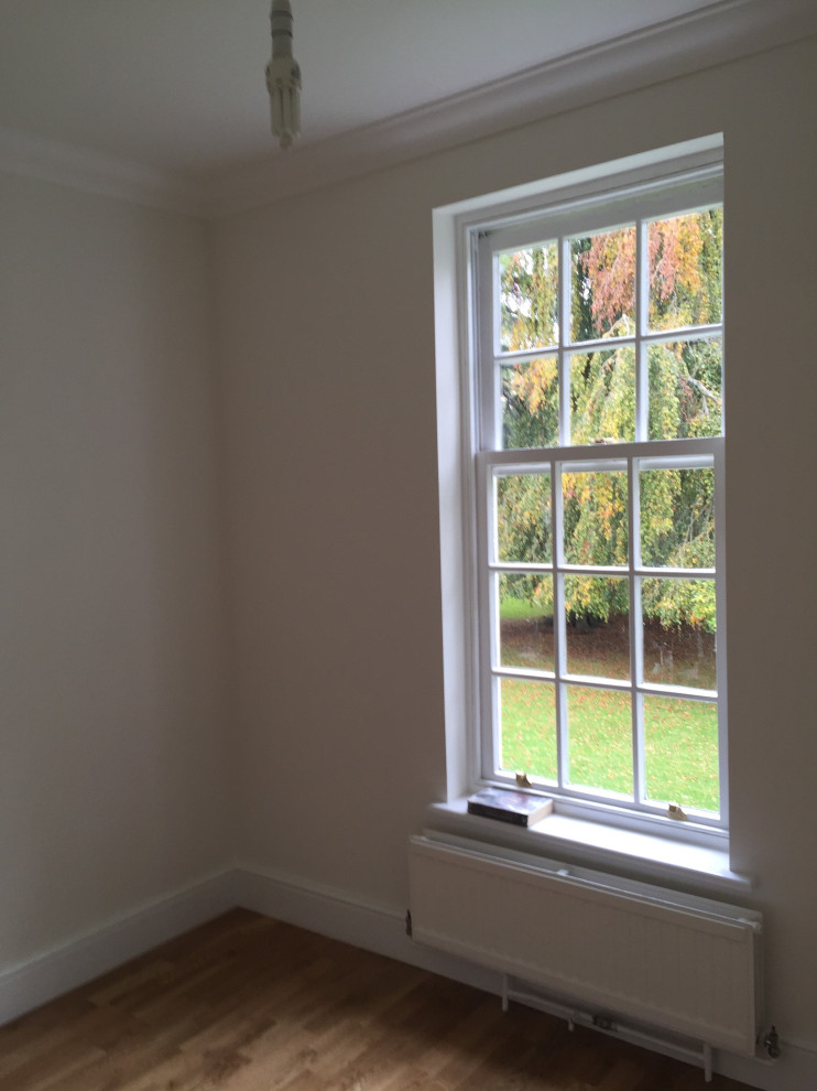 Großes Klassisches Wohnzimmer mit weißer Wandfarbe, Laminat und braunem Boden in Hampshire