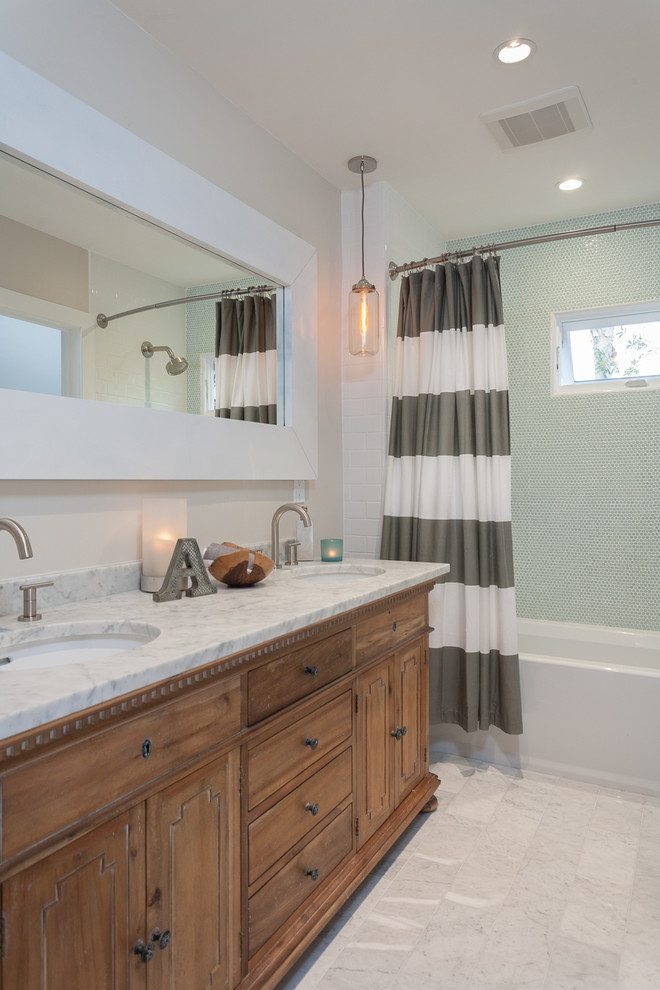 Design ideas for a transitional bathroom in Orange County with an undermount sink, medium wood cabinets, an alcove tub, a shower/bathtub combo, white tile, flat-panel cabinets, marble benchtops and stone tile.
