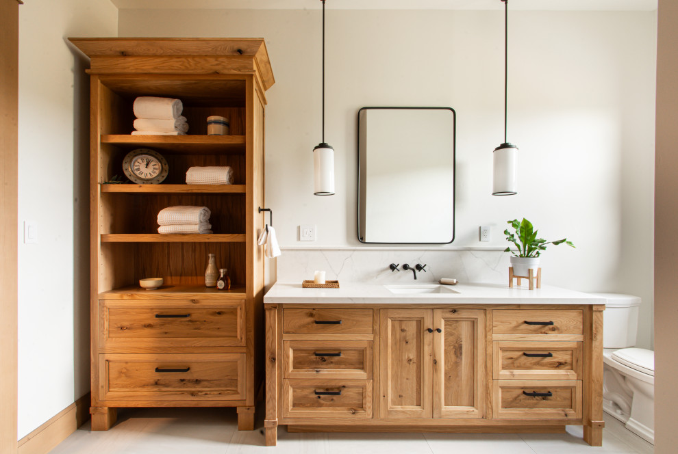 Photo of a large classic family bathroom in San Francisco with recessed-panel cabinets, light wood cabinets, a two-piece toilet, white walls, porcelain flooring, a submerged sink, engineered stone worktops, grey floors, white worktops, a single sink and a freestanding vanity unit.