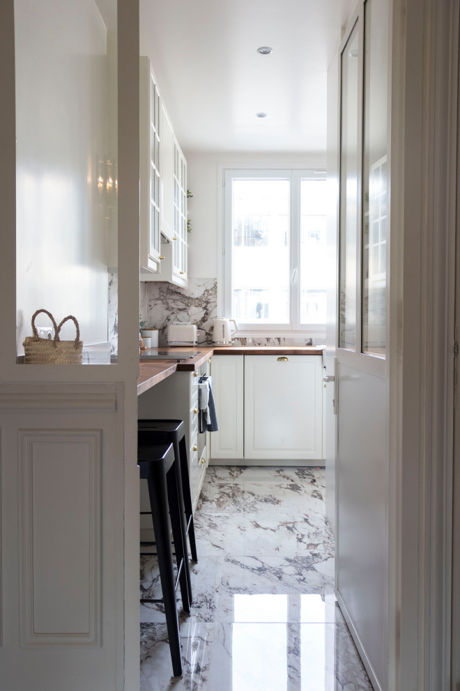 Exempel på ett avskilt, mellanstort klassiskt brun brunt l-kök, med en enkel diskho, luckor med glaspanel, vita skåp, träbänkskiva, vitt stänkskydd, spegel som stänkskydd, rostfria vitvaror, klinkergolv i keramik och vitt golv