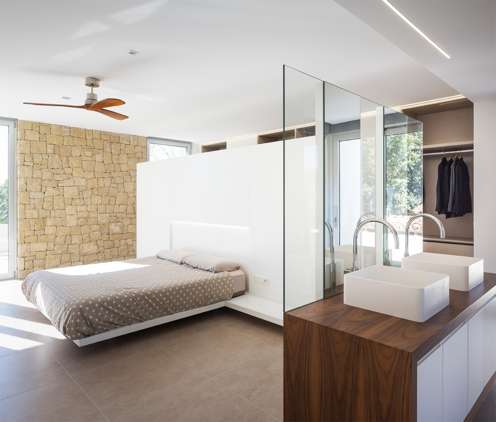 Photo of a large contemporary master bedroom in Valencia with white walls and grey floor.