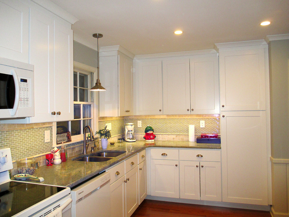 Transitional l-shaped eat-in kitchen photo with an undermount sink, shaker cabinets, white cabinets, granite countertops, beige backsplash and white appliances