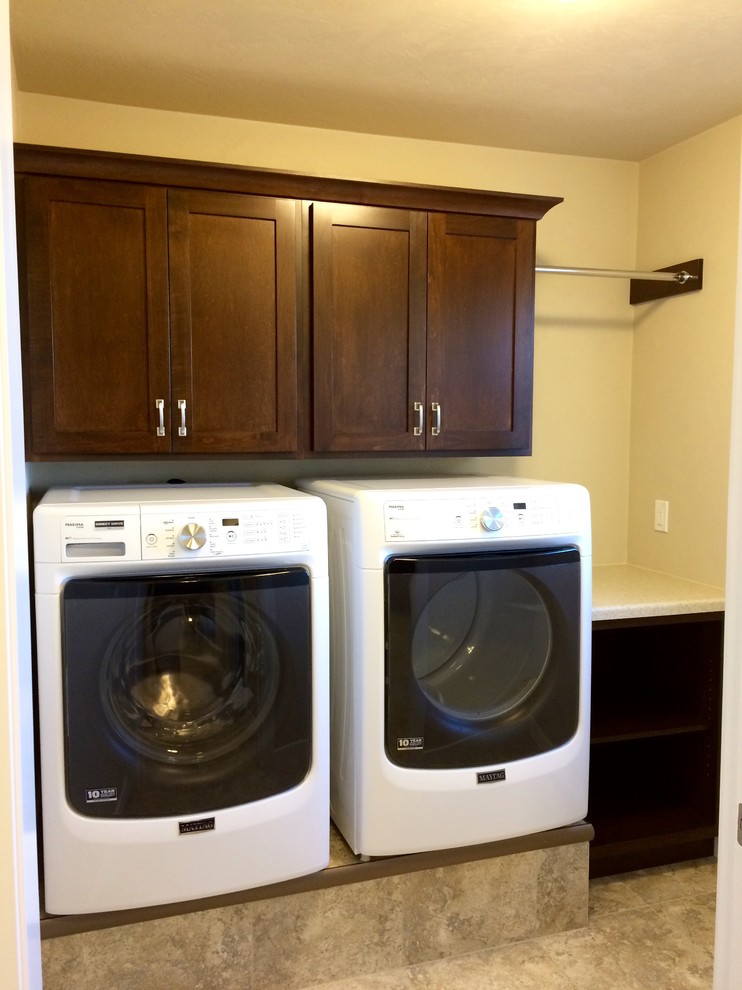 Inspiration for a mid-sized arts and crafts single-wall dedicated laundry room in Other with shaker cabinets, medium wood cabinets, laminate benchtops, beige walls, vinyl floors and a side-by-side washer and dryer.