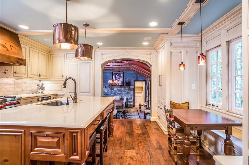Inspiration for a large traditional l-shaped eat-in kitchen in Atlanta with an undermount sink, beaded inset cabinets, white cabinets, marble benchtops, beige splashback, stainless steel appliances, medium hardwood floors, with island, brown floor and beige benchtop.