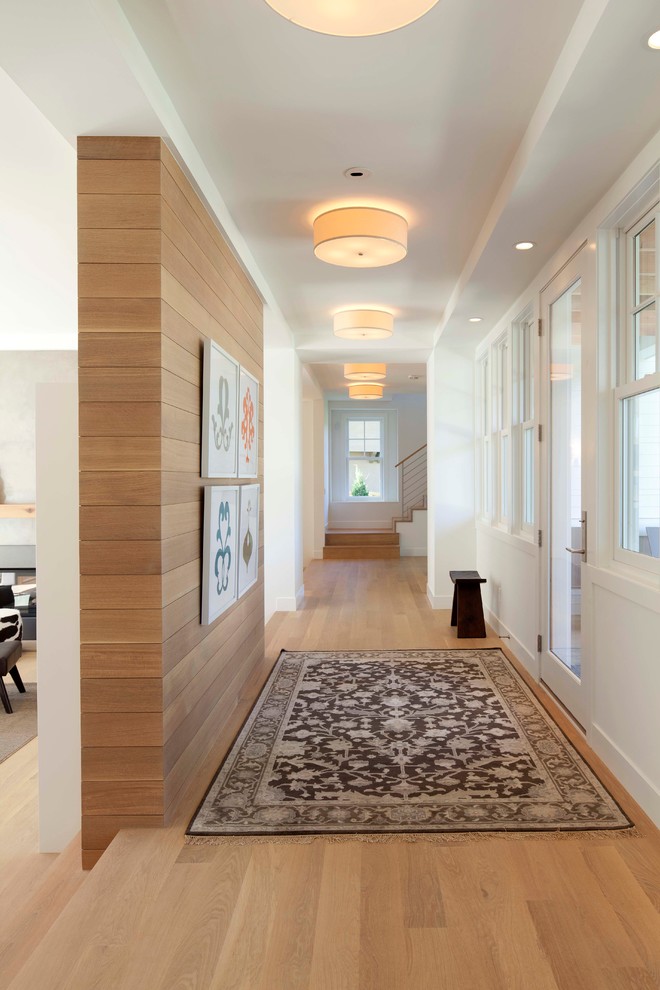 Design ideas for a contemporary hallway in Minneapolis with white walls and medium hardwood floors.