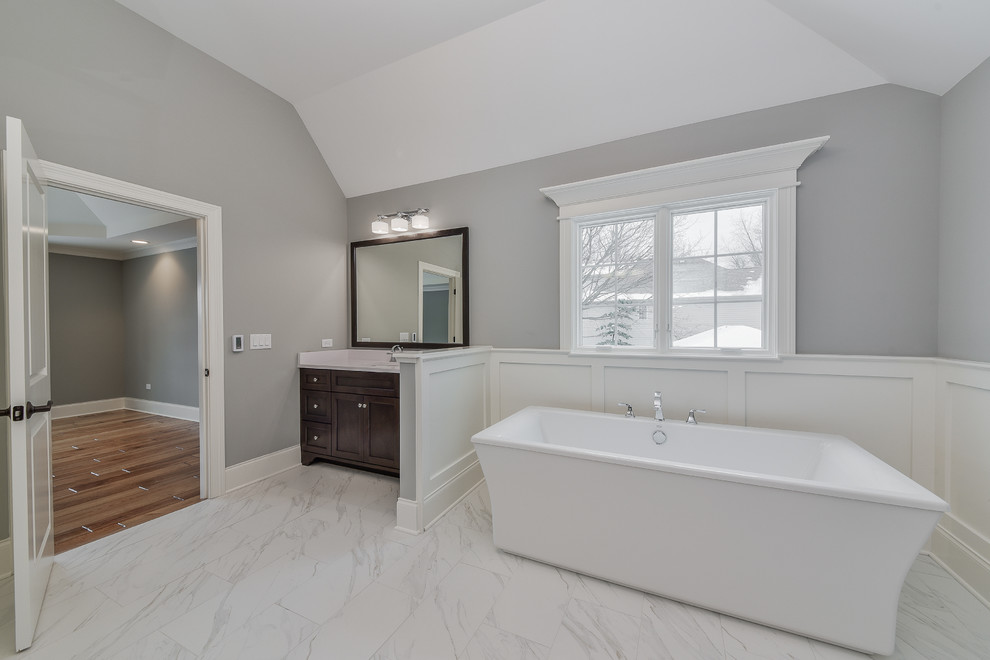 Photo of a large transitional master bathroom in Chicago with shaker cabinets, dark wood cabinets, a freestanding tub, an open shower, a two-piece toilet, white tile, ceramic tile, grey walls, ceramic floors, an undermount sink, quartzite benchtops, multi-coloured floor and a hinged shower door.