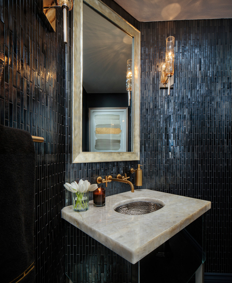 This is an example of a mid-sized transitional powder room in Los Angeles with furniture-like cabinets, a one-piece toilet, black tile, glass tile, black walls, dark hardwood floors, an undermount sink, onyx benchtops and brown floor.
