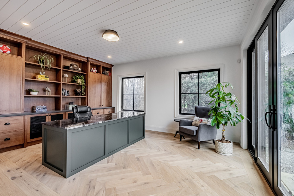 Ejemplo de despacho de estilo de casa de campo grande sin chimenea con paredes blancas, suelo de madera clara, escritorio independiente, suelo beige y machihembrado