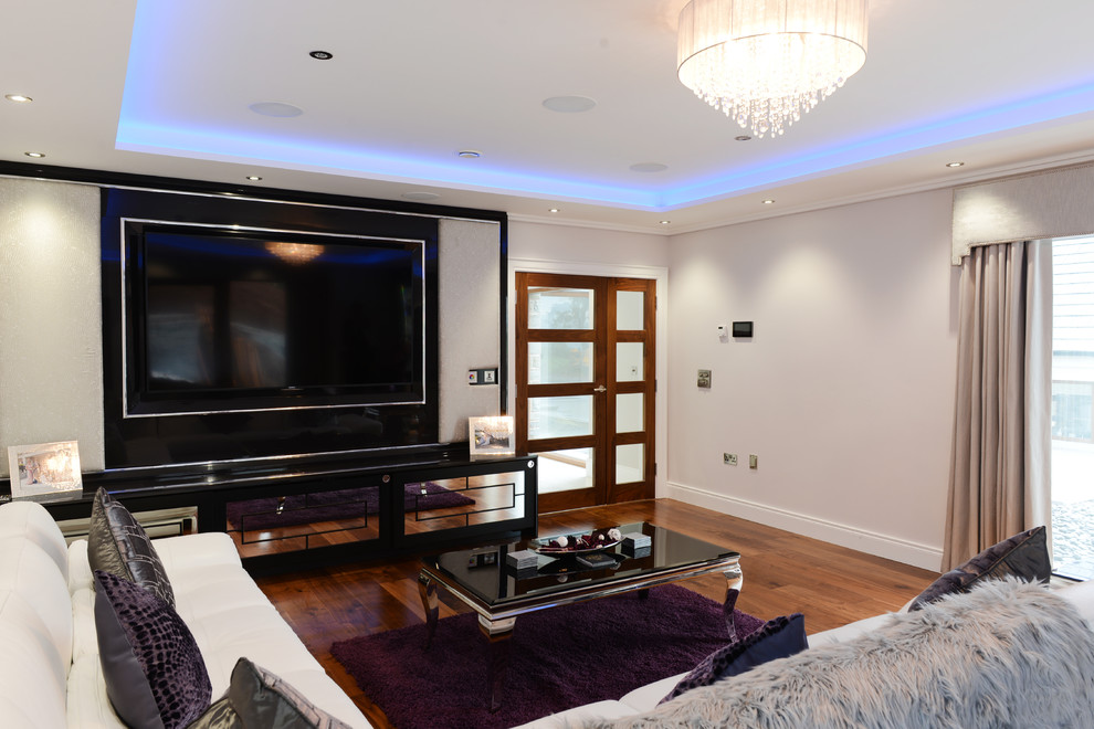 Mid-sized transitional home theatre in Belfast with grey walls, dark hardwood floors and a wall-mounted tv.