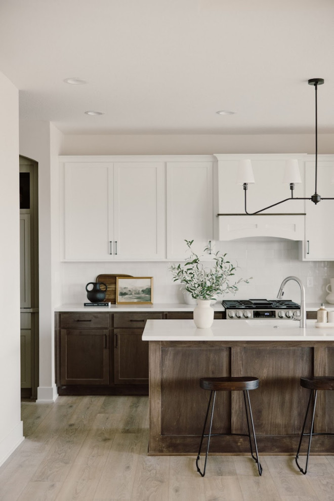 Inspiration for a large modern l-shaped kitchen pantry in Omaha with an undermount sink, recessed-panel cabinets, dark wood cabinets, laminate benchtops, white splashback, ceramic splashback, white appliances, vinyl floors, with island, multi-coloured floor, white benchtop and vaulted.