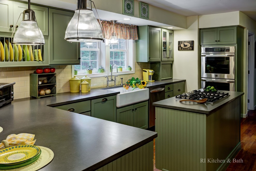 Foto på ett stort lantligt kök, med en rustik diskho, skåp i shakerstil, gröna skåp, granitbänkskiva, gult stänkskydd, stänkskydd i keramik, rostfria vitvaror, mellanmörkt trägolv och en köksö