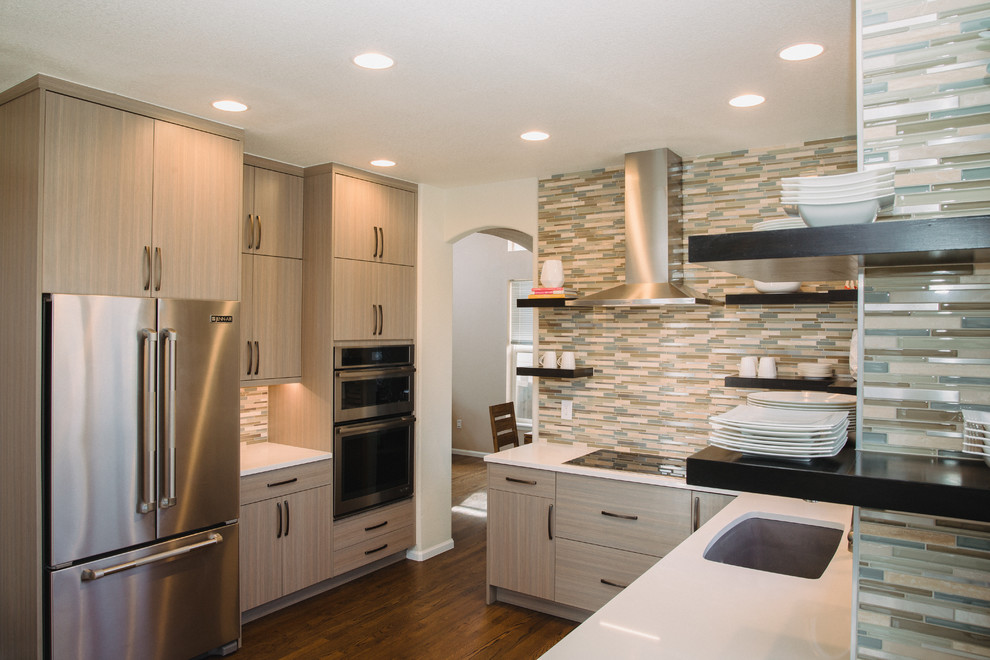 Inspiration for a mid-sized contemporary u-shaped eat-in kitchen in Denver with an undermount sink, flat-panel cabinets, beige cabinets, quartz benchtops, green splashback, mosaic tile splashback, stainless steel appliances, medium hardwood floors, no island, brown floor and white benchtop.