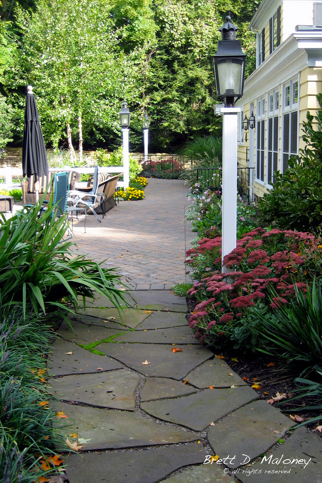 Photo of a large traditional backyard full sun xeriscape for summer in Other with a garden path and concrete pavers.