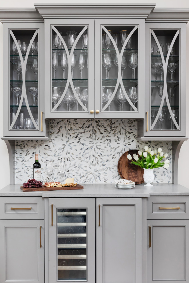 Inspiration for a transitional single-wall home bar in Charlotte with recessed-panel cabinets, grey cabinets, grey splashback, mosaic tile splashback, grey benchtop and no sink.