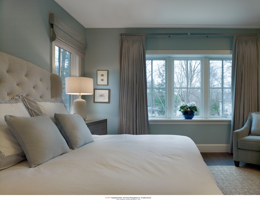 Photo of a transitional bedroom in New York with blue walls and dark hardwood floors.