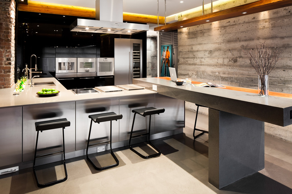 Large industrial u-shaped open plan kitchen in Vancouver with an undermount sink, flat-panel cabinets, medium wood cabinets, concrete benchtops, black splashback, ceramic splashback, stainless steel appliances, concrete floors and a peninsula.