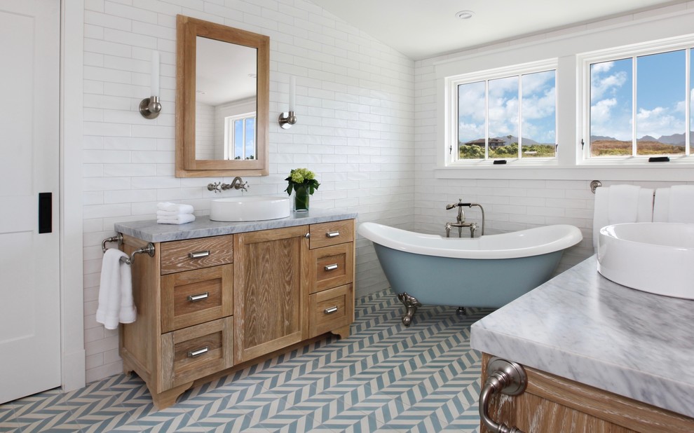 Inspiration for a tropical bathroom in Hawaii with shaker cabinets, medium wood cabinets, a claw-foot tub, white tile, white walls, a vessel sink, blue floor and grey benchtops.