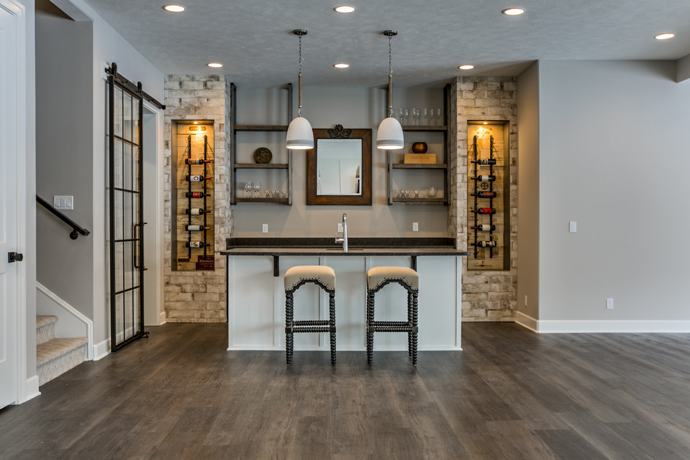 Photo of a transitional seated home bar in Omaha with an undermount sink, shaker cabinets, granite benchtops, porcelain splashback, carpet and black benchtop.