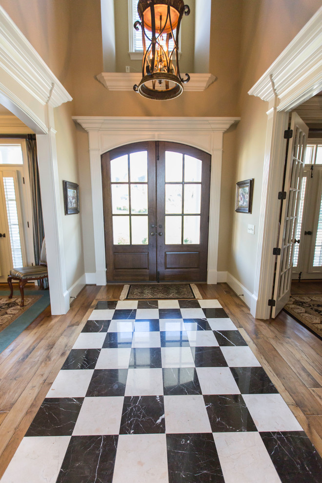This is an example of a mid-sized transitional front door in Raleigh with beige walls, medium hardwood floors, a double front door and a dark wood front door.