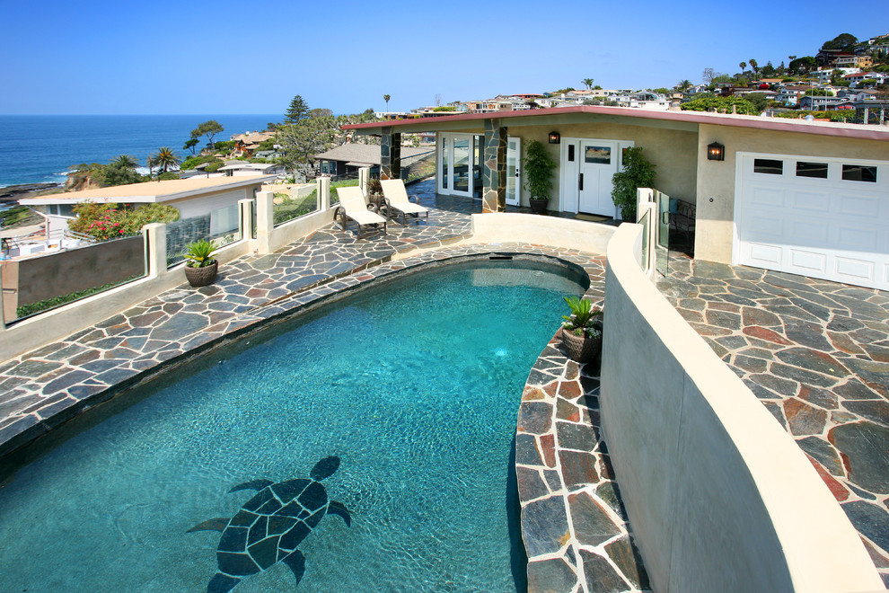 Design ideas for an eclectic front yard custom-shaped pool in Orange County with natural stone pavers.