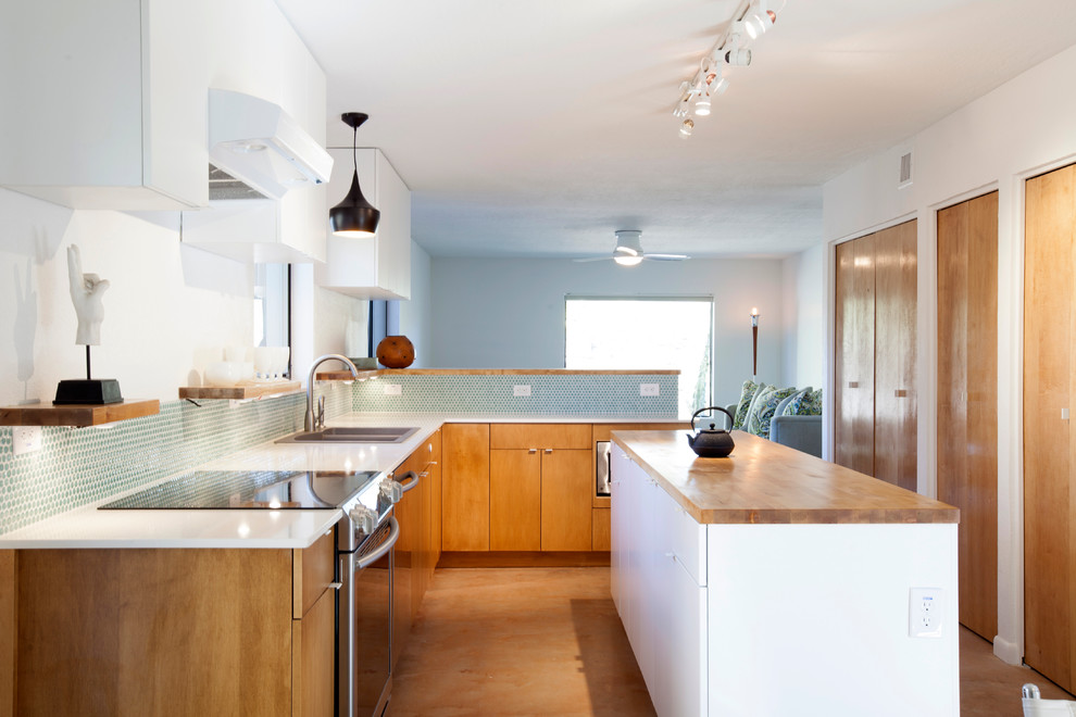 Inspiration for a midcentury l-shaped open plan kitchen in Phoenix with a drop-in sink, flat-panel cabinets, medium wood cabinets, quartz benchtops and stainless steel appliances.