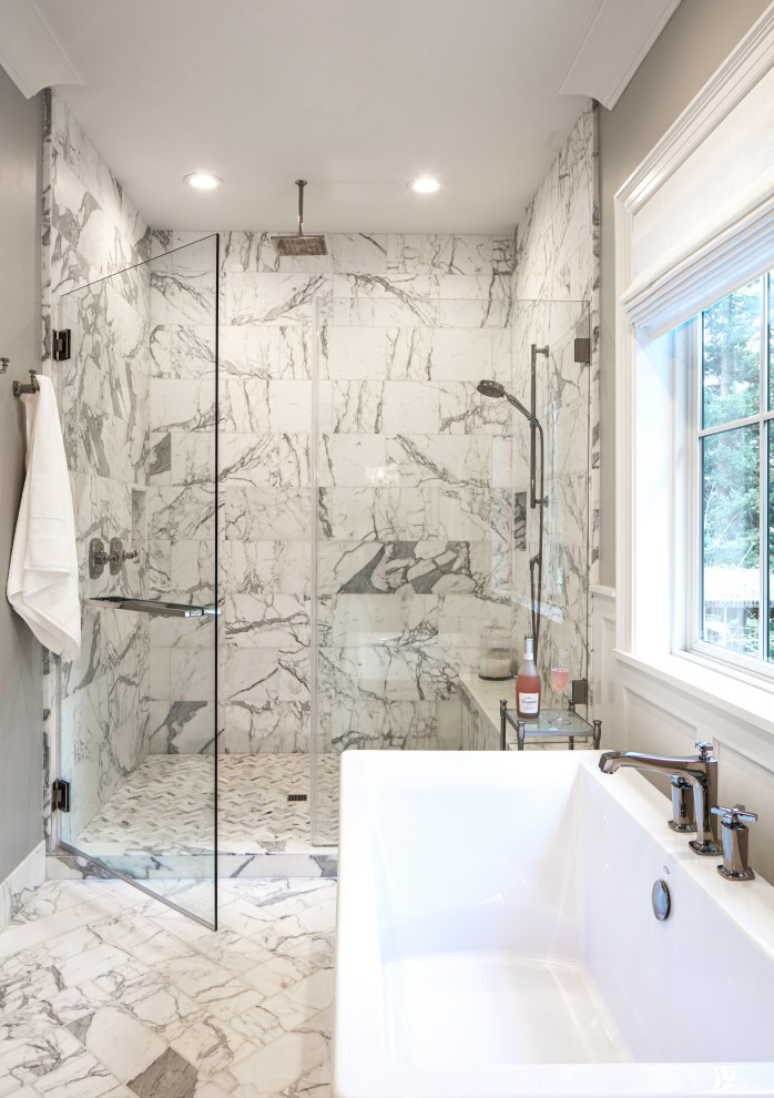 This is an example of a large transitional master bathroom in San Francisco with shaker cabinets, white cabinets, a freestanding tub, a double shower, a one-piece toilet, grey walls, marble floors, an undermount sink, marble benchtops, white floor, a hinged shower door, white benchtops, an enclosed toilet, a double vanity, a built-in vanity and panelled walls.