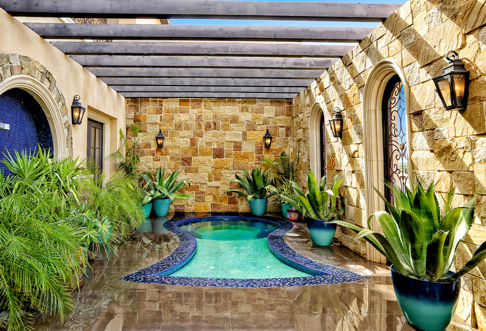 Inspiration for an expansive mediterranean courtyard custom-shaped pool in Austin with a hot tub and tile.
