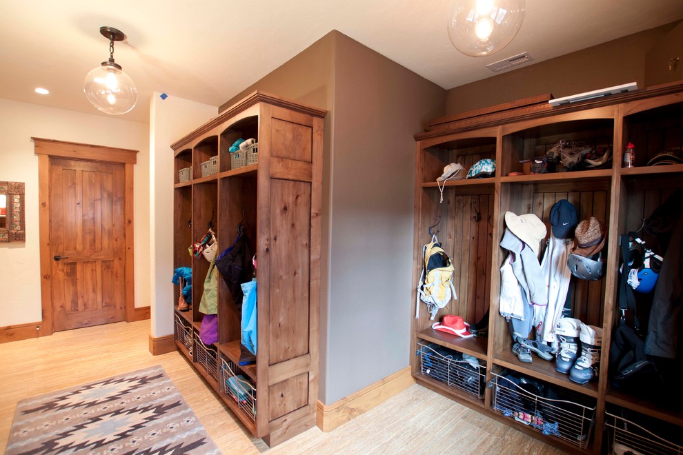 Inspiration for a large country mudroom in Denver with brown walls and travertine floors.