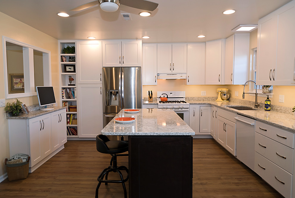 Inspiration for a mid-sized transitional l-shaped eat-in kitchen in Baltimore with an undermount sink, shaker cabinets, white cabinets, quartz benchtops, beige splashback, stainless steel appliances, medium hardwood floors, with island and brown floor.