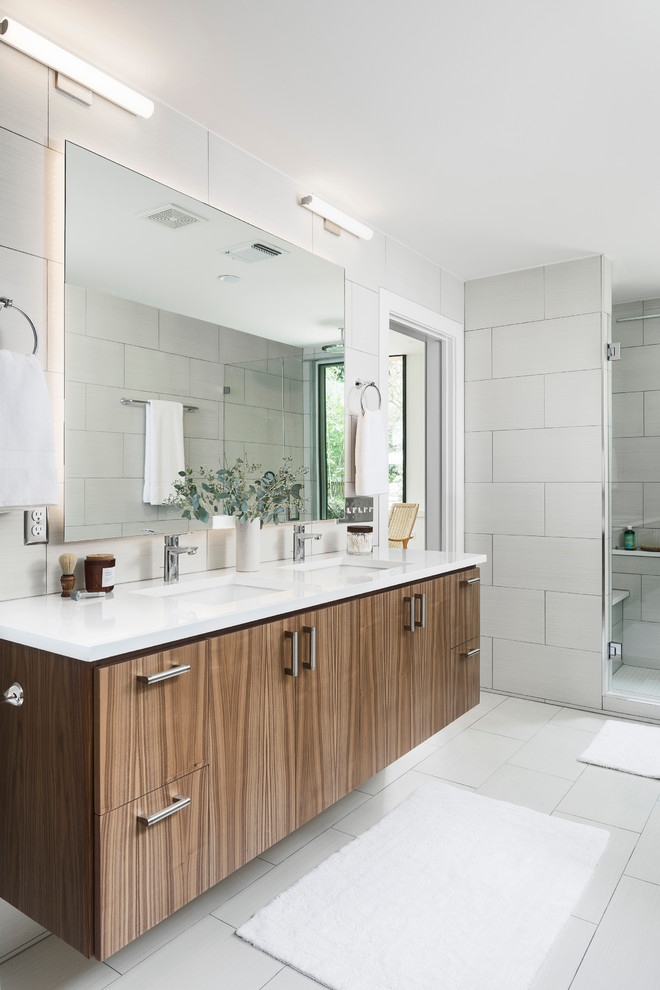 Contemporary bathroom in Austin with flat-panel cabinets, dark wood cabinets, an alcove shower, white tile, an undermount sink, white floor and a hinged shower door.