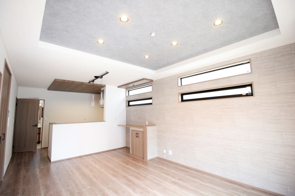 モダンスタイルのおしゃれなLDK (白い壁、合板フローリング、茶色い床、折り上げ天井、壁紙、グレーの天井) の写真