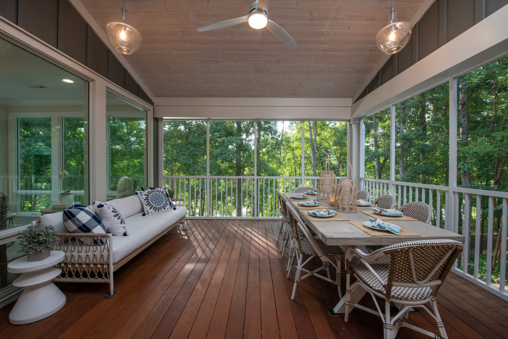 Photo of a large transitional backyard screened-in verandah in Other with metal railing.