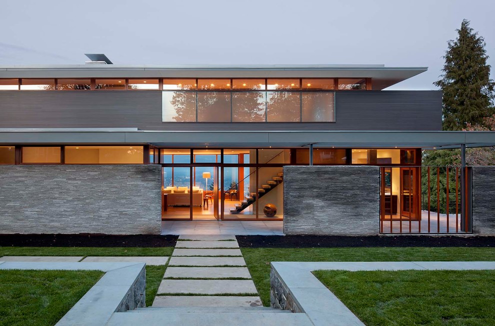 Photo of a mid-sized contemporary two-storey glass house exterior in Portland with a flat roof.