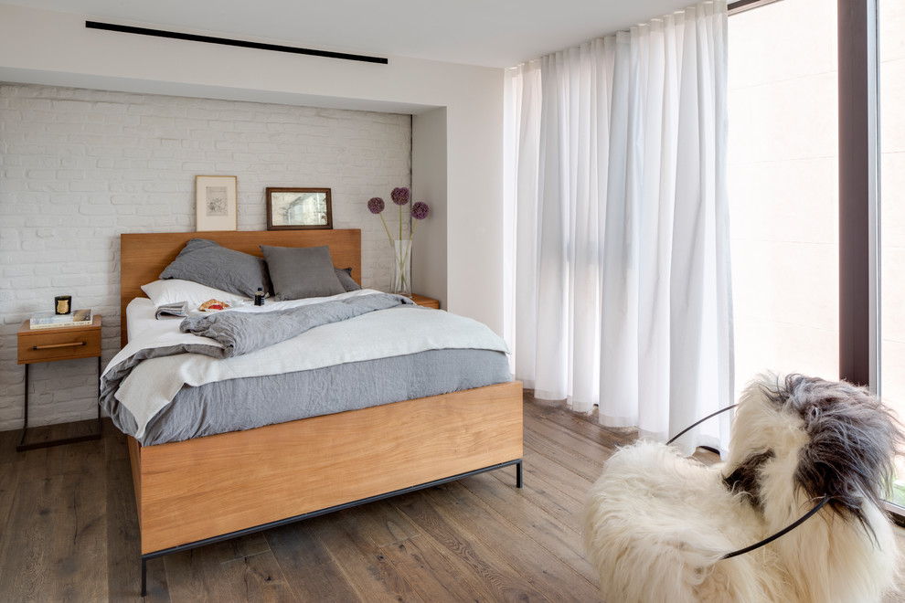 Photo of a mid-sized scandinavian master bedroom in New York with white walls, dark hardwood floors, brown floor and no fireplace.