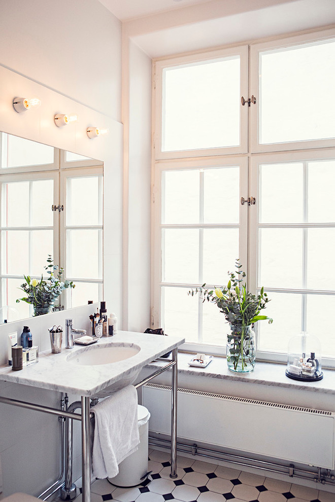 This is an example of a small scandinavian master bathroom in Stockholm with multi-coloured tile, ceramic tile, white walls, ceramic floors, a drop-in sink and marble benchtops.