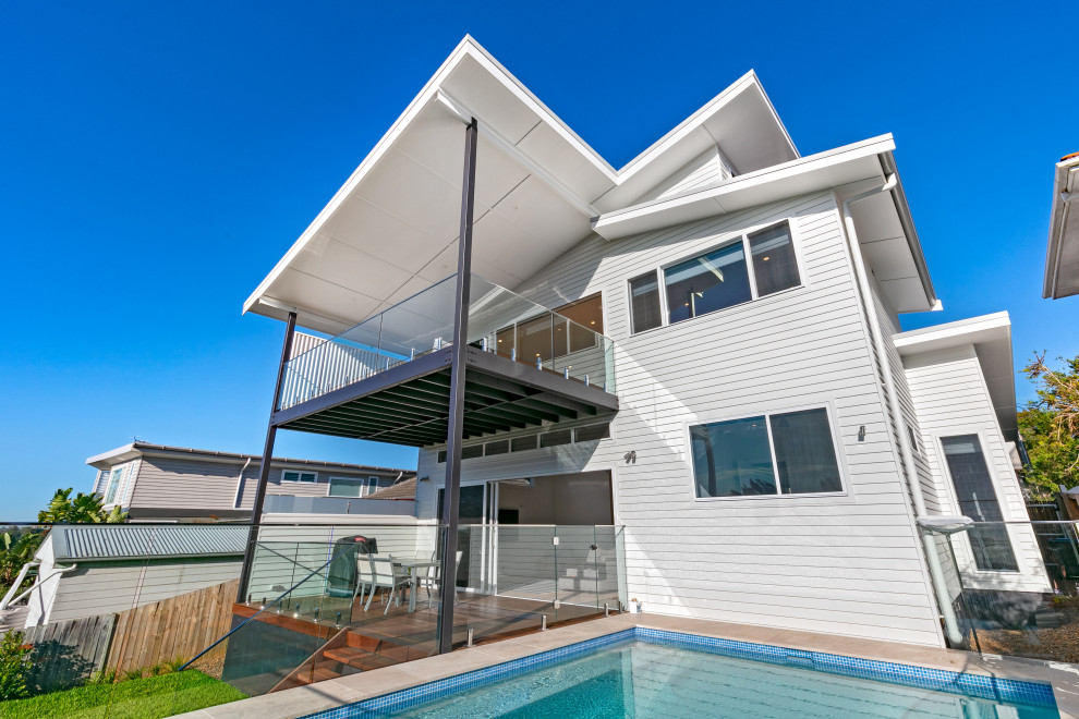 Photo of a medium sized beach style back rectangular above ground swimming pool in Sydney with natural stone paving.