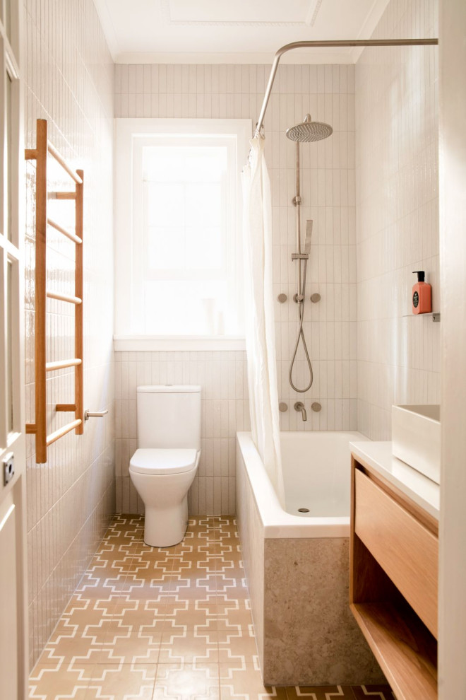 Exemple d'une salle de bain tendance en bois clair avec un placard à porte plane, une baignoire d'angle, un combiné douche/baignoire, un carrelage blanc, une vasque, un sol beige, une cabine de douche avec un rideau, un plan de toilette blanc, meuble simple vasque et meuble-lavabo suspendu.