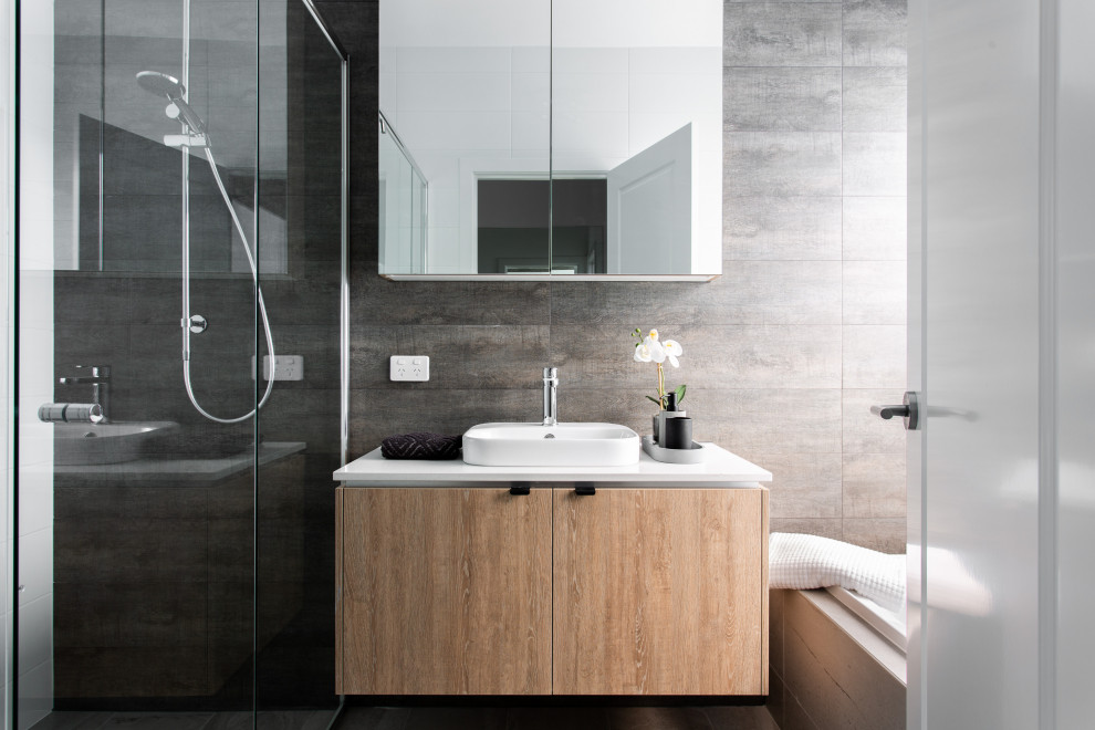 Contemporary bathroom in Adelaide with flat-panel cabinets, medium wood cabinets, gray tile, a vessel sink, white benchtops, a single vanity and a floating vanity.
