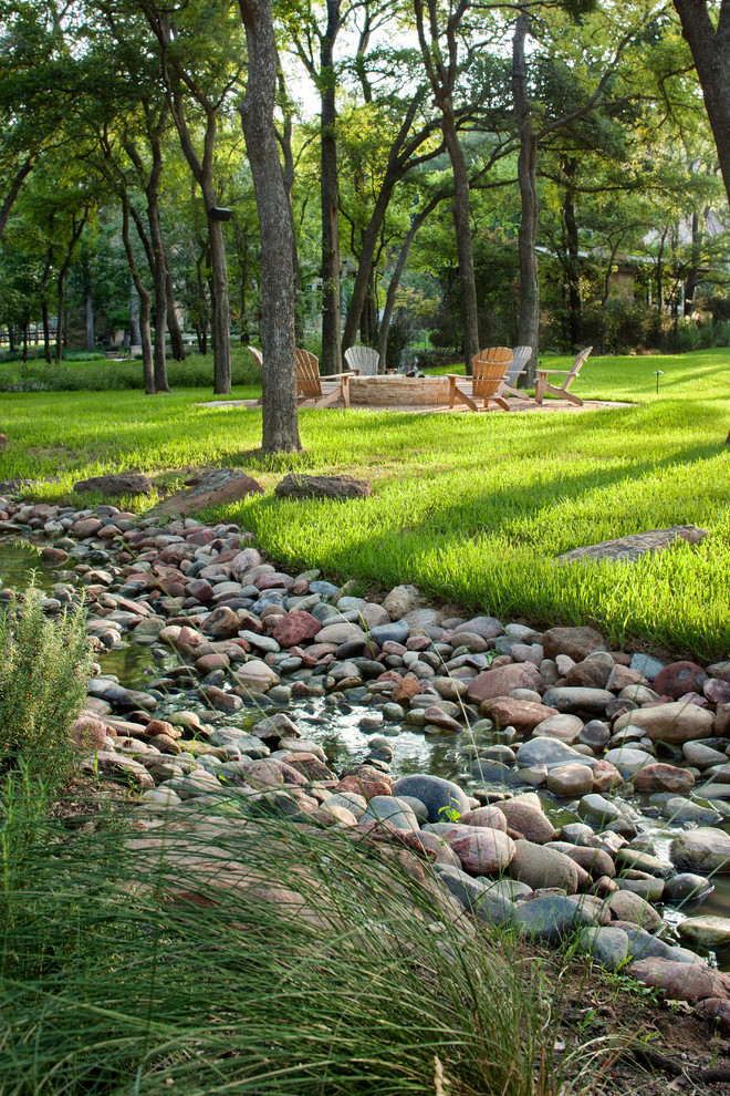 Inspiration for an expansive mediterranean backyard garden in Austin with a water feature.