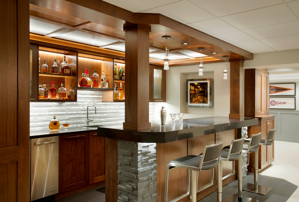 This is an example of a large transitional galley seated home bar in Boston with an undermount sink, open cabinets, medium wood cabinets, solid surface benchtops, grey splashback and stone tile splashback.