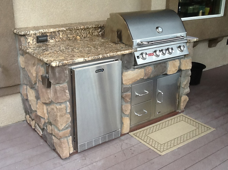 Inspiration for a rustic backyard outdoor kitchen deck remodel in Denver with a roof extension