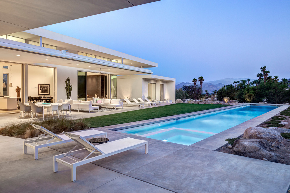 Design ideas for a midcentury backyard rectangular lap pool in Los Angeles with concrete slab.