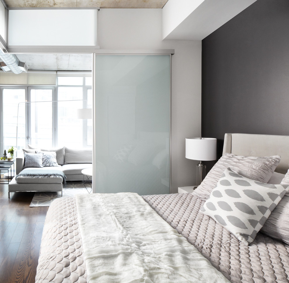 Contemporary bedroom in Dallas with grey walls and dark hardwood floors.