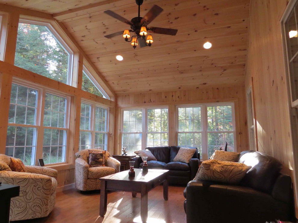 Example of a large classic medium tone wood floor sunroom design in Manchester with a standard ceiling