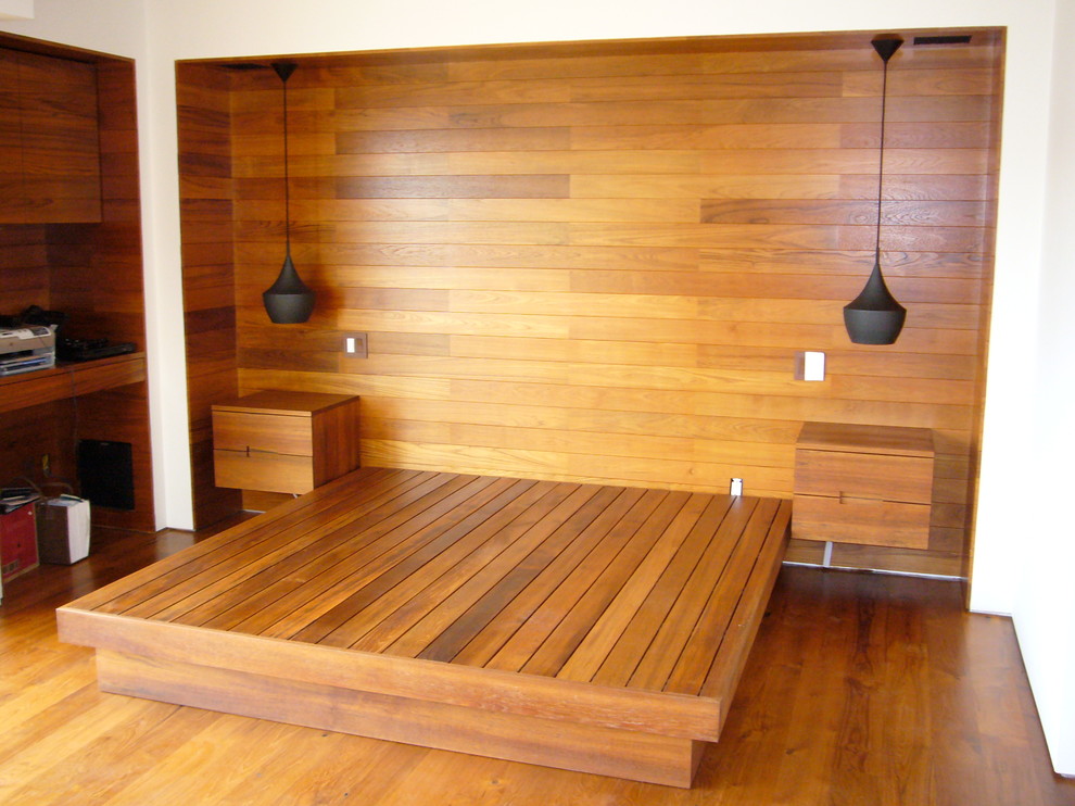 This is an example of a large modern guest bedroom in Other with brown walls and light hardwood floors.