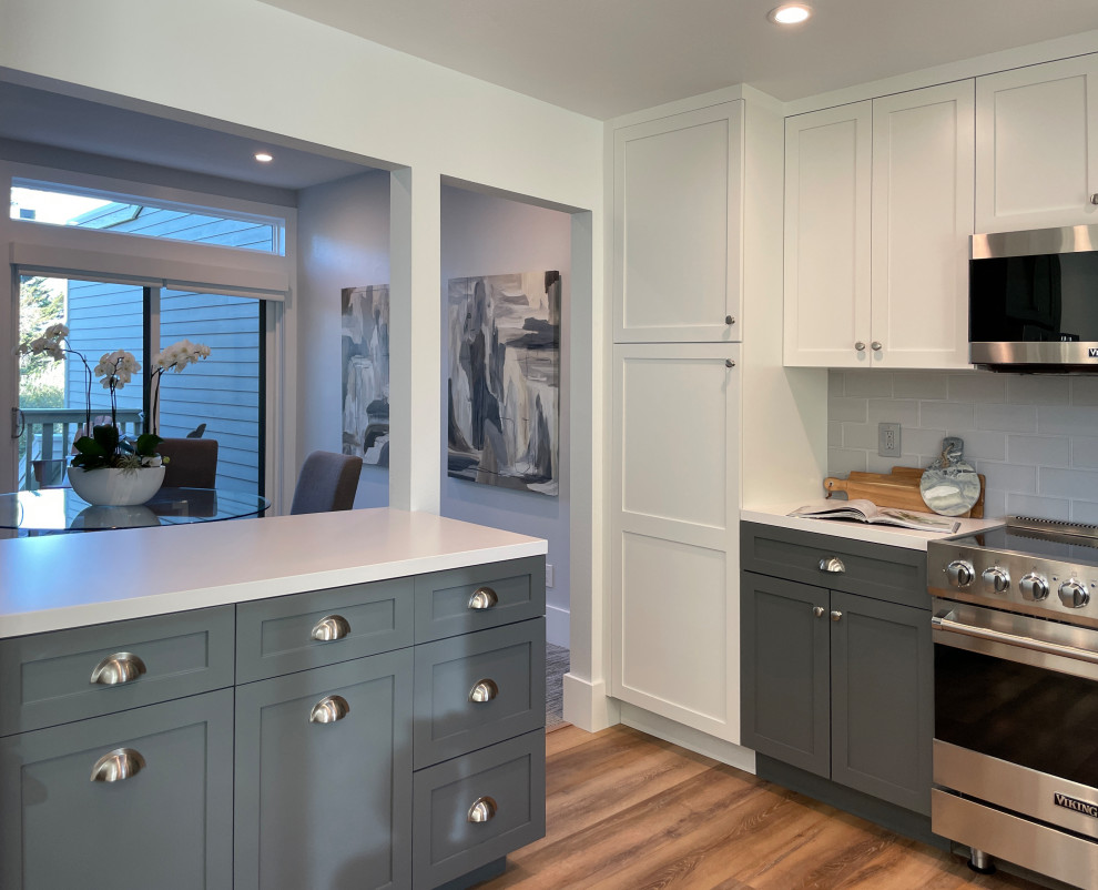 Mid-sized trendy u-shaped medium tone wood floor and brown floor enclosed kitchen photo in San Francisco with an undermount sink, shaker cabinets, gray cabinets, quartz countertops, gray backsplash, ceramic backsplash, stainless steel appliances, a peninsula and white countertops