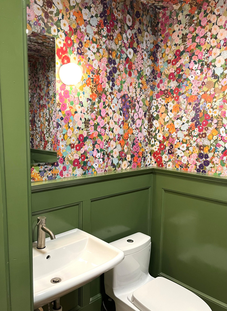 Exempel på ett litet eklektiskt grön grönt toalett, med vita skåp, en toalettstol med hel cisternkåpa, flerfärgade väggar, ljust trägolv, ett väggmonterat handfat, träbänkskiva och brunt golv