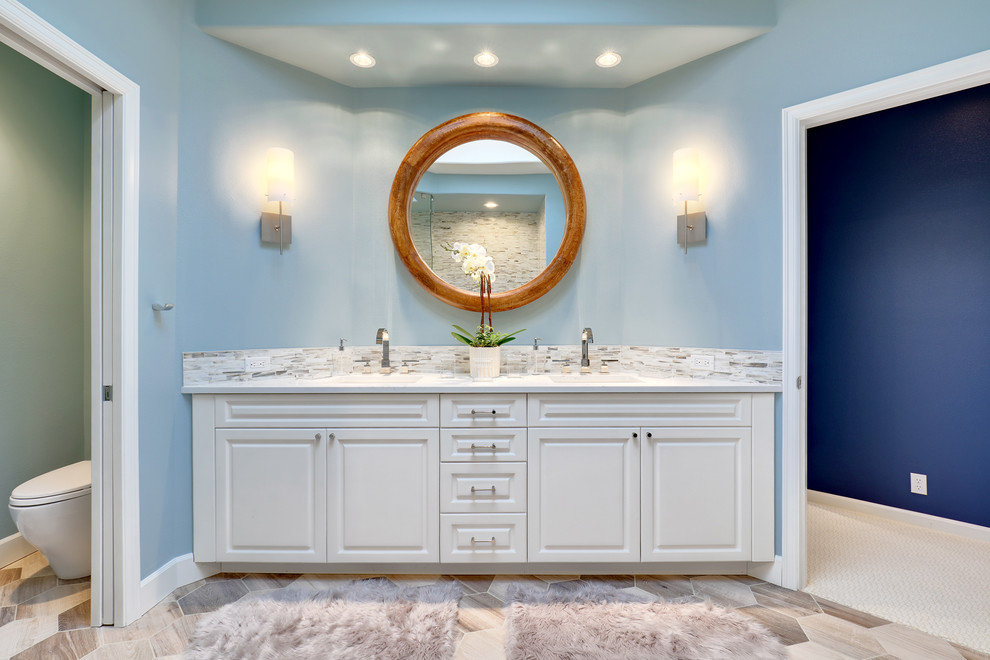 Mid-sized transitional master bathroom in Orange County with raised-panel cabinets, white cabinets, an open shower, a two-piece toilet, gray tile, white tile, matchstick tile, blue walls, porcelain floors, an undermount sink and engineered quartz benchtops.