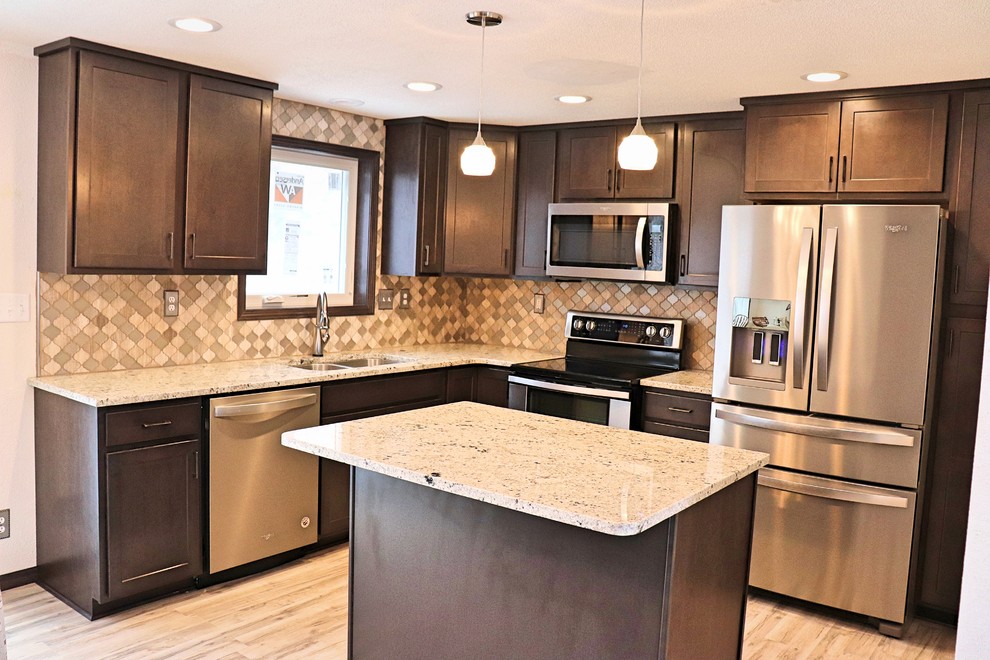 Inspiration for a small transitional u-shaped laminate floor and gray floor eat-in kitchen remodel in Cedar Rapids with an undermount sink, recessed-panel cabinets, dark wood cabinets, granite countertops, gray backsplash, mosaic tile backsplash, stainless steel appliances, an island and white countertops