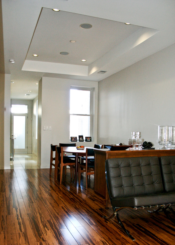 Photo of a small modern dining room in DC Metro with white walls, bamboo floors and no fireplace.
